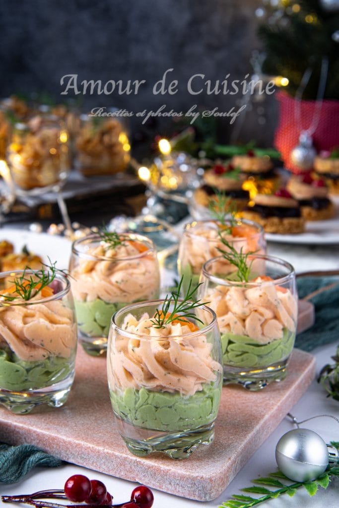 Verrines apéritives élégantes à la mousse de saumon et crème d’avocat, garnies d’aneth et d’œufs de poisson, servies sur un plateau en pierre, avec un décor festif en arrière-plan